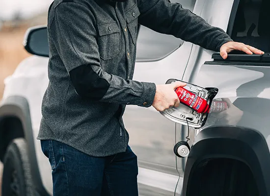Person adds bottle of AMSOIL P.i. to his truck